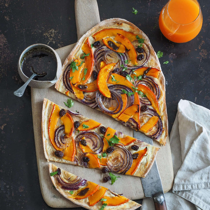 Kürbis-Flammkuchen mit roten Zwiebeln, Weinbeeren und Kürbiskern-Würzöl-Topping