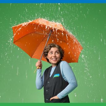 Reformhaus Beraterin mit orangen Regenschirm im Regen