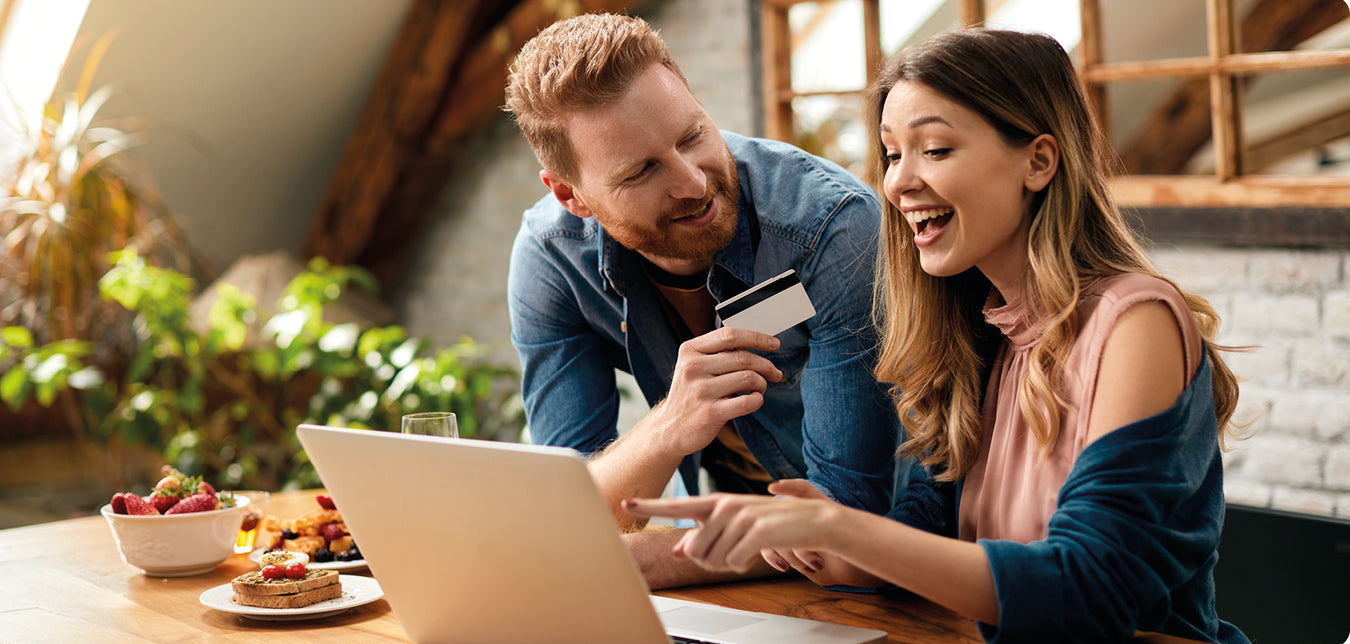 Junges paar vor dem Laptop beim Online-Shopping